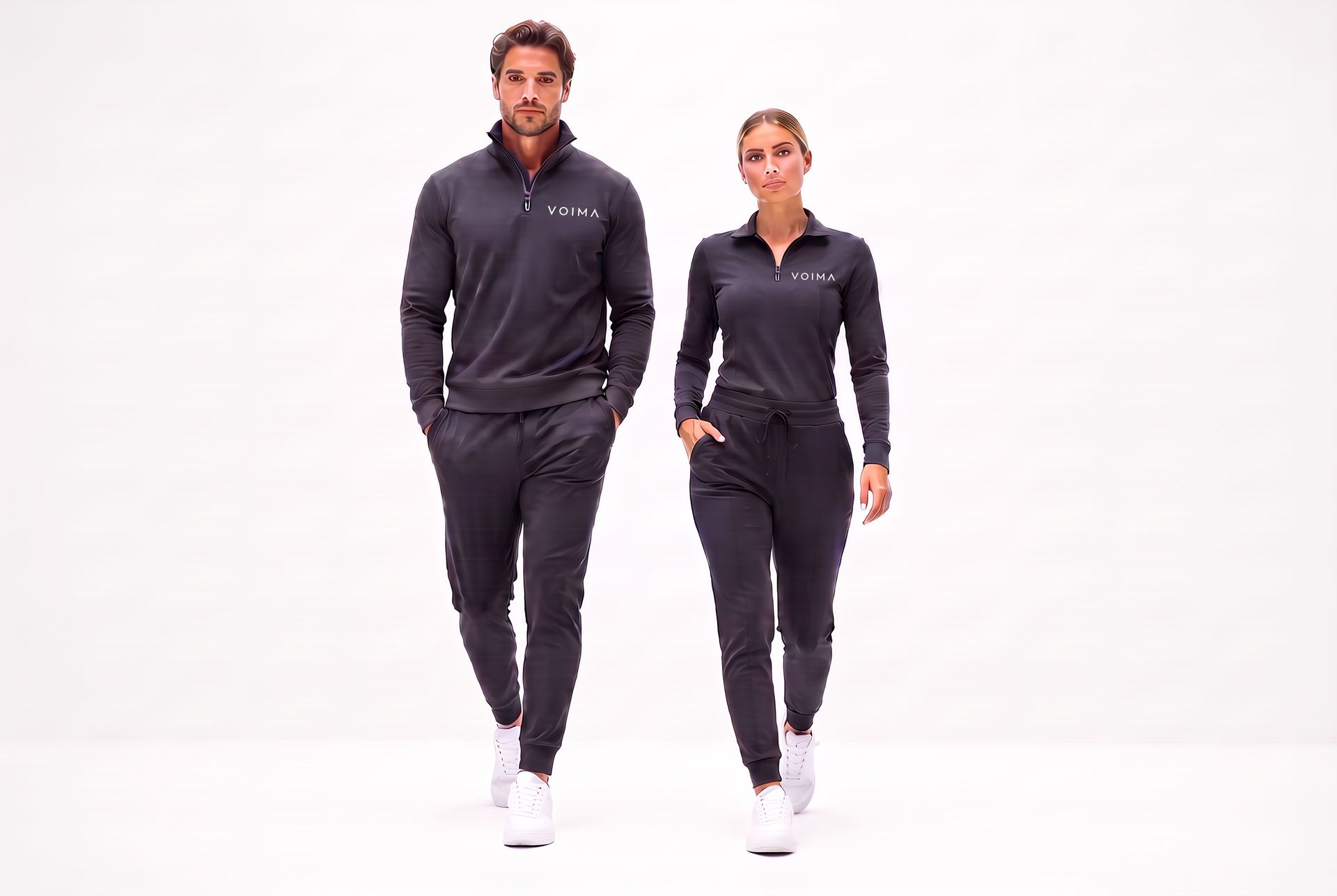 A man and woman walk toward the camera wearing sleek charcoal Voima leisure and business-casual layers